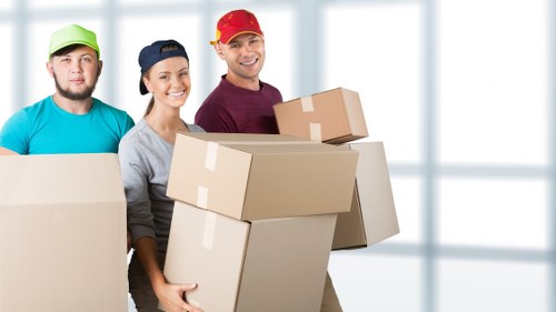Removal team loading household furniture into a van in London